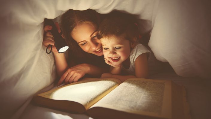 Family reading bedtime. Mom and child reading book